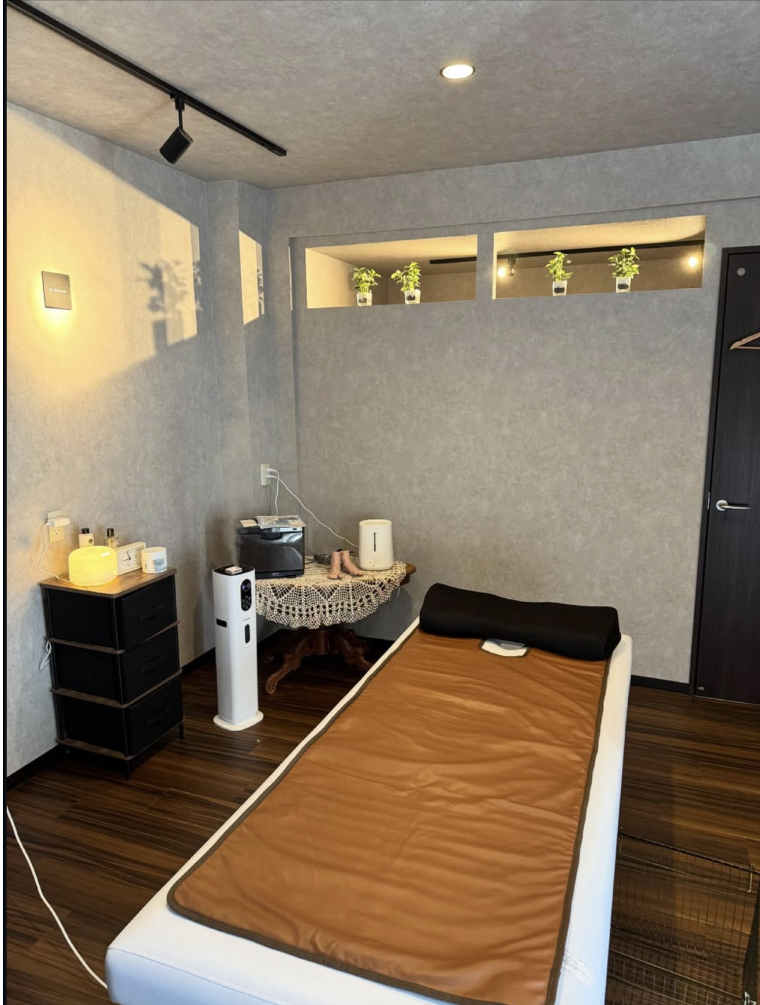 落ち着いた間接照明の店内と施術ベッド
